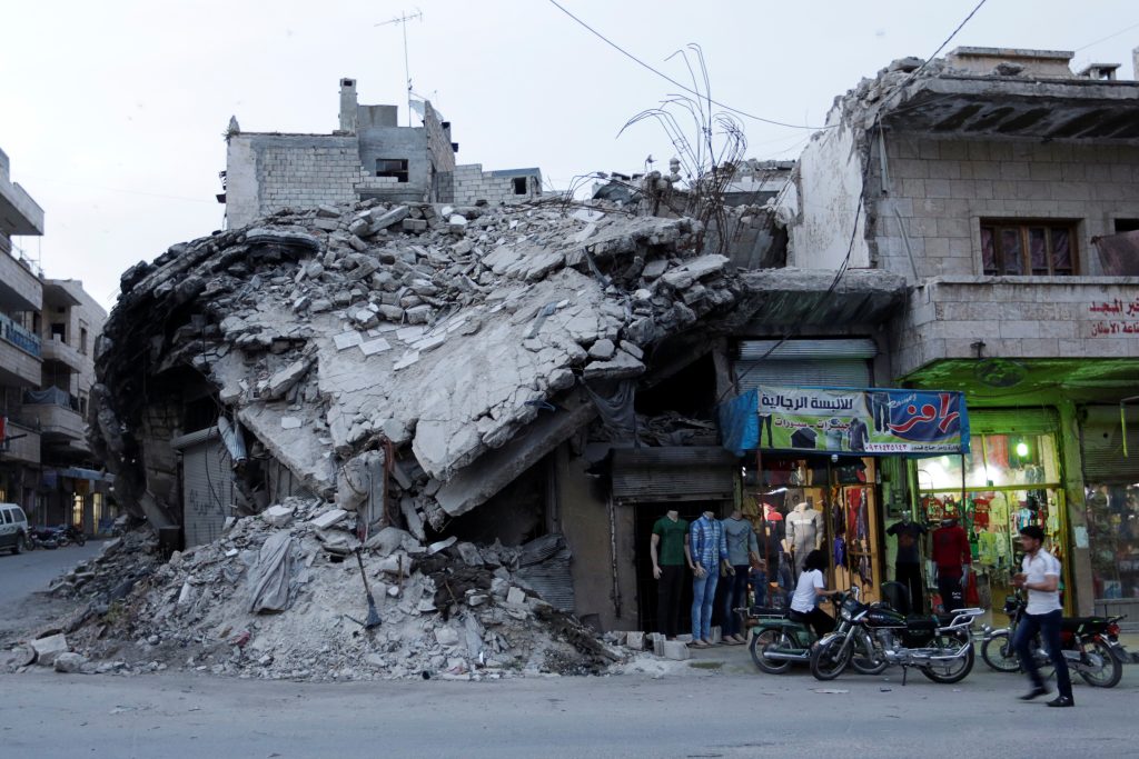 A clothing shop displays its merchandise beside a damaged building in the rebel-controlled area of Maaret al-Numan town in Idlib province, Syria, May 15, 2016. REUTERS/Khalil Ashawi