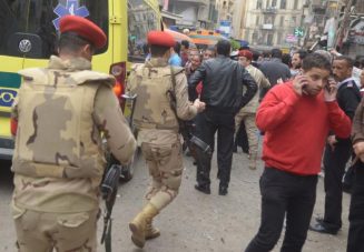 Egypt army members take position as people react at a scene after an attack by a suicide bomber in front of a church in Alexandria