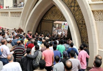 Egyptians gather in front of a Coptic church that was bombed on Sunday in Tanta