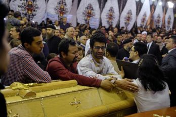 Relatives of victims react next to coffins arriving to the Coptic church that was bombed on Sunday in Tanta