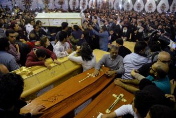 Relatives of victims react to coffins arriving to the Coptic church that was bombed on Sunday in Tanta